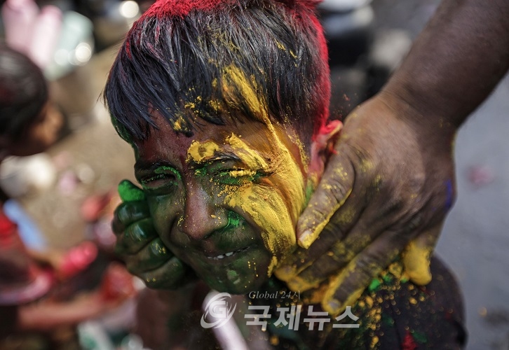 [국제뉴스]Boy reacts as his father applies coloured powder to