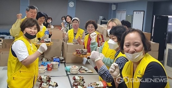 식료품 세트 포장 중인 강전권 부군수와 자원봉사센터 회원들  모습(사진=단양군)