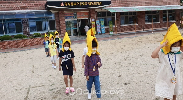 지진방재 모자를 쓰고 질서있게 운동장으로 대피하는 유아들