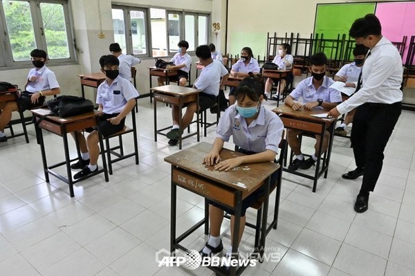 신종 코로나바이러스의 위협으로 임시 휴교한 뒤 개교한 학교가 2020년 7월 1일 방콕의 막카산 피타야 정부 중등학교에서 교사가 학생들에게 출석을 확인하고 있다. ⓒAFPBBNews