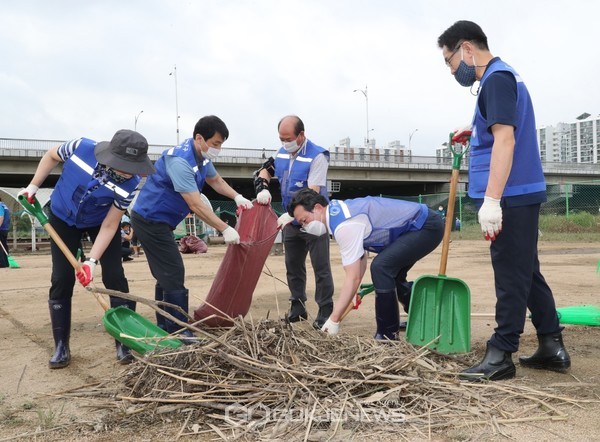채현일 영등포구청장(오른쪽 두 번째)과 김영주 국회의원, 구의원들이 함께 하천 둔치에 쌓인 나뭇가지 등 쓰레기 청소에 힘쏟고 있다.