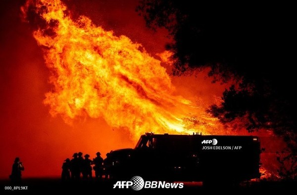부테 카운티 소방관들은 2020년 9월 9일 캘리포니아주 오로빌에서 발생한 베어 화재 당시 트럭 위로 화염탑으로 지켜보고 있다.ⓒAFPBBNews