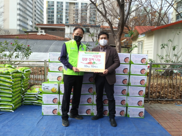 경북하나센터 김기현 사무국장과 김규환 포항창포1관리소장이 24일 북한이탈주민들과 함께 담은 김장김치를 들어보이고 있다. (사진 = 경북하나센터)