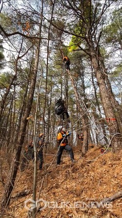 패러글라이딩 중 나무에 걸려 고립된 50대 남성을 무사히 구조하고 있다.