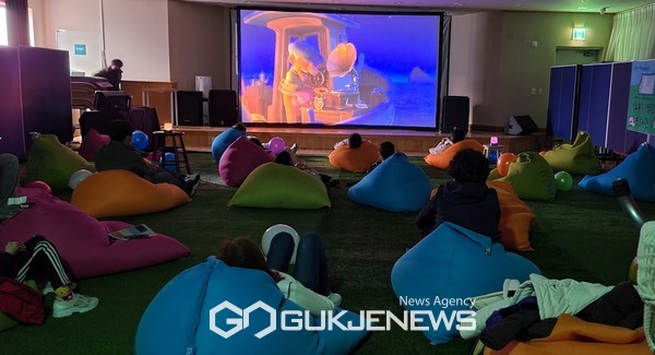 독산4동 지역 아이들과 주민들이 주민센터 문화관람실에서 영화를 관람하고 있다