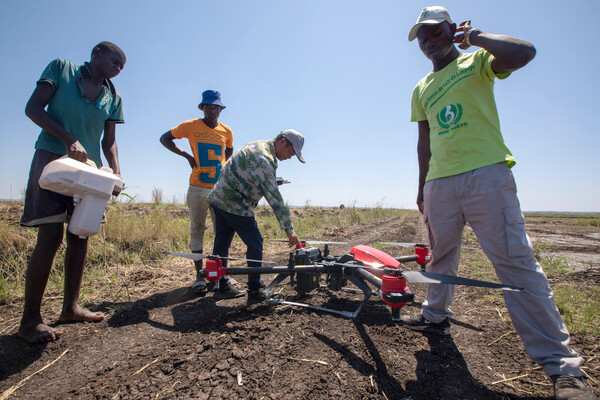 Em 28 de novembro de 2019, um técnico agrícola chinês (segundo da direita) ensina trabalhadores locais a pulverizar herbicidas por drone em uma fazenda de arroz em Jajai Wanbao, sul de Moçambique.  (Foto / Contatos da Xinhua)