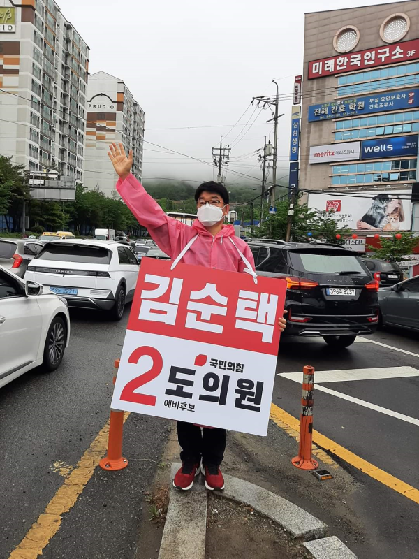 김순택 도의원 예비후보가 거리인사를 하고 있는 장면.