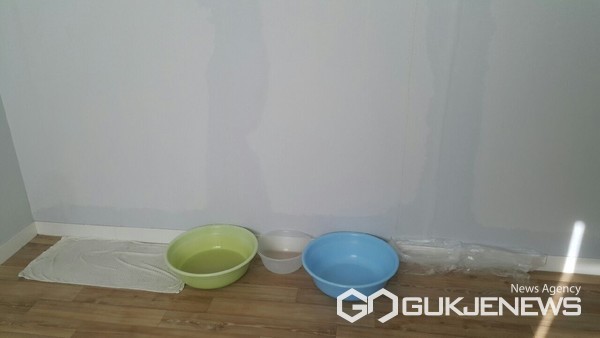 벽이 물이 새 바가지로 받혀놓은 모습./입주민 제공