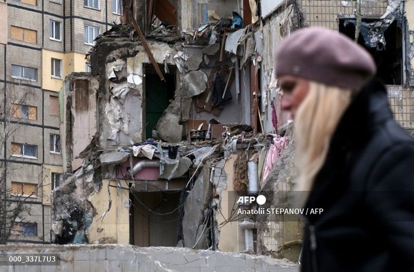 한 여성이 2023년 1월 22일 우크라이나 드니프로 시에 있는 미사일 공격을 받은 주택 건물을 지나가고 있다. 사진제공/AFP통신
