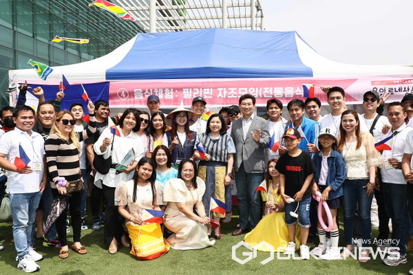 (사진=용인시)이상일 용인특례시장이 필리핀 자조 모임 부스를 방문, 필리핀 다문화 가족들과 함께 기념 사진을 찍고 있다.