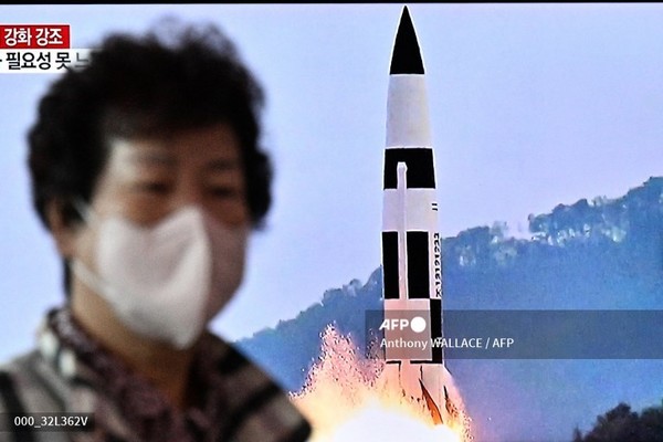 2022년 10월 10일 서울 철도역에서 한 여성이 북한 미사일 발사 관련 뉴스가 보도되는 TV 앞을 지나가고 있다. 사진제공/AFP통신