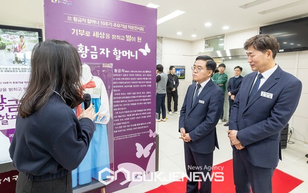진교훈 강서구청장(오른쪽 두 번째)이 8일(금) 구청 1층 로비에서 열린 ‘일본군 위안부 피해자 고(故) 황금자 할머니 10주년 추모 전시회’에서 할머니의 양아들인 김정환 강서구청 생활보장과장(맨 오른쪽)과 함께 할머니의 유품을 둘러보고 있다. [사진제공=강서구청]