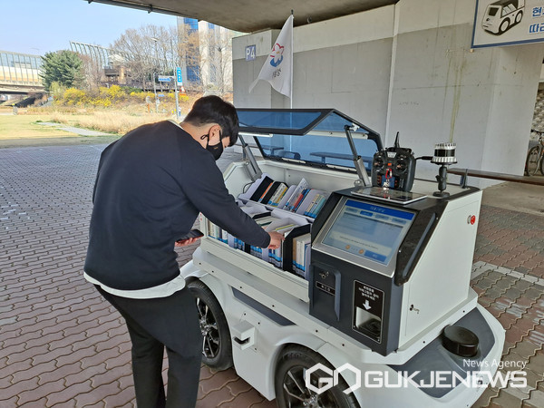 성남시 자율주행 도서관 로봇 ‘카북이’가 탄천교에 정차해 한 시민이 빌려갈 책을 고르고 있다(성남시)