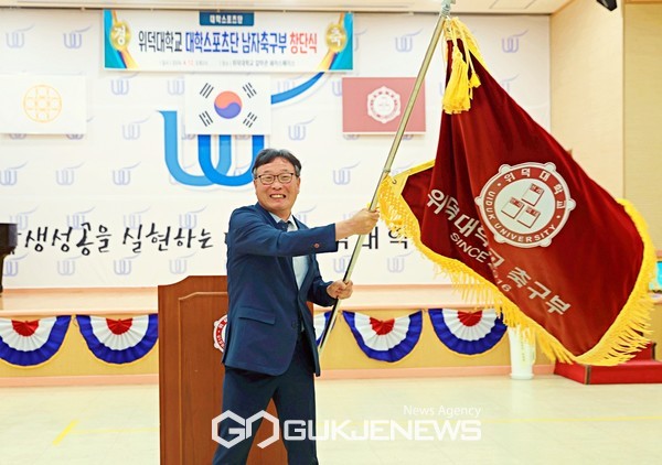 유동관 위덕대 감독이 12일 본교 내 갈마간 쉐어스페이스홀에서 열린 축구부 창단식에서 축구부 단기를 휘날리고 있다(사진=김병용 기자)