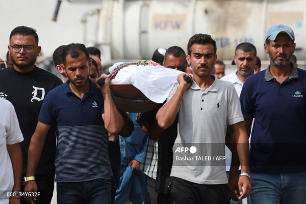 팔레스타인 남성들이 2024년 6월 22일 팔레스타인 도시 라파 북서쪽 알 마와시 지역에서 전날 일어난 공습으로 사망한 시신을 매장하기 위해 옮기고 있다. 사진제공/AFP통신