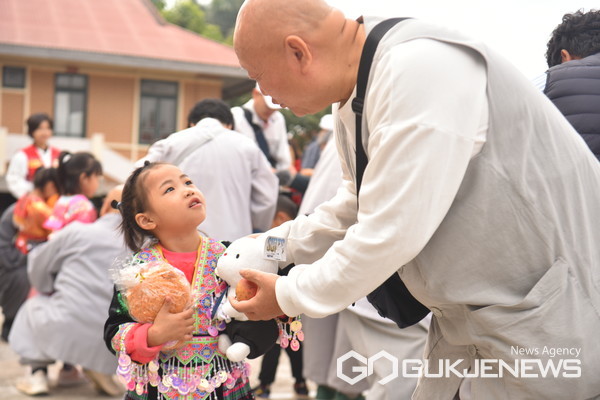 원융승가회 소속 스님이 SOS 어린이 마을의 한 아이에게 인형을 선물하고 있다. / 사진 = 법보신문 제공