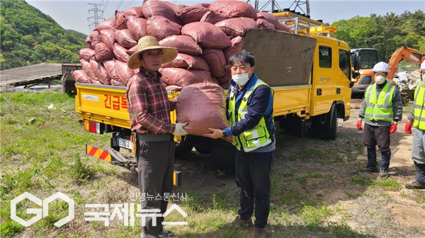 공단 도로처가 소나무 폐임목으로 만든 우드칩을 지역농가에 기부하고 있다/제공=부산시설공단