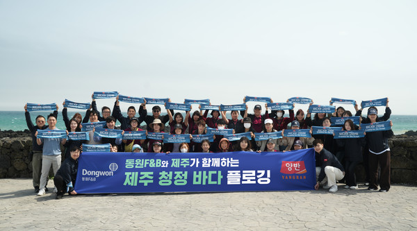 서귀포시 표선면 일대에서 진행된 ‘제주 청정 바다 플로깅’ 행사에서 동원F&B 직원들이 기념사진 촬영을 하고 있다.(사진=동원F&B)