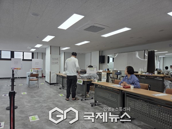 한 주민이 투표용지를 받기전 진행요원에게 유권자 확인차 신분증을 제시 하고 있다/박의규 기자