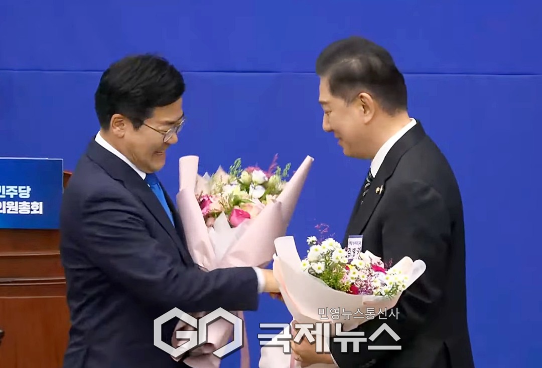 ▲더불어민주당 박찬대 전 원내대표가 김병기 신임 원내대표에게 꽃다발을 전달하며 축하하고 있다./사진=이용우 기자