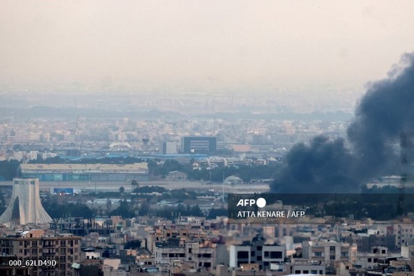16일 이란 테헤란 중심부 아자디 타워(왼쪽) 인근에서 이스라엘의 공습을 받아 연기가 피어오르고 있다. 사진제공/AFP통신