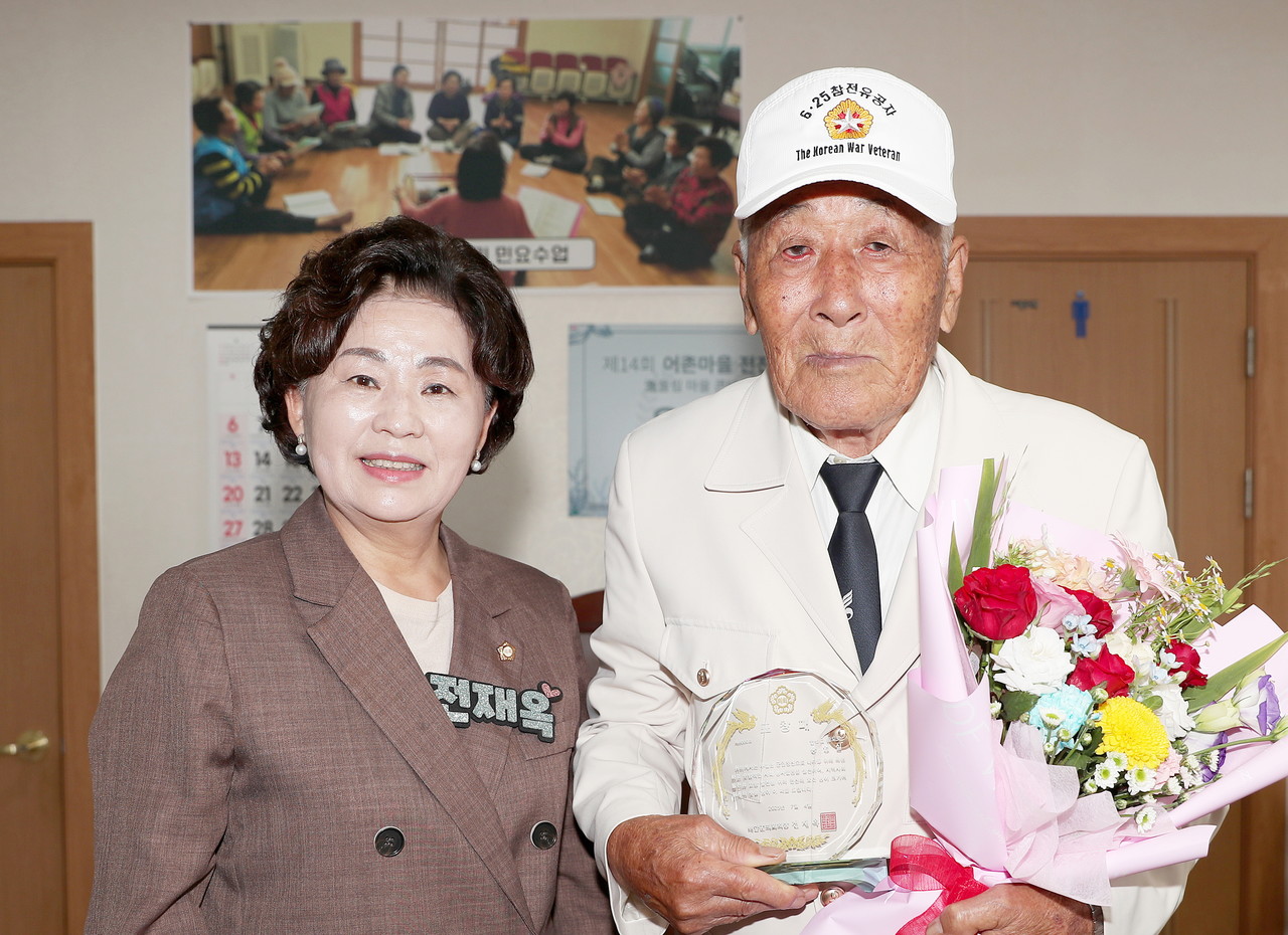 지난 4일 전재옥 충남 태안군의장(사진 왼쪽)이 유공자에 시상을 마치고 기념촬영을 하고 있다(사진/태안군의회 제공)