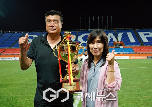 챔피언 정읍신태인축구센터U18 이문희 총감독이 2일 제주월드컵경기장에서 열린 제33회 백록기 전국고등학교축구대회 시상식 후 신태인고등학교 김미양 교장선생님과 기념 촬영에 임하고 있다(사진=제주도축구협회 박정미 이사)