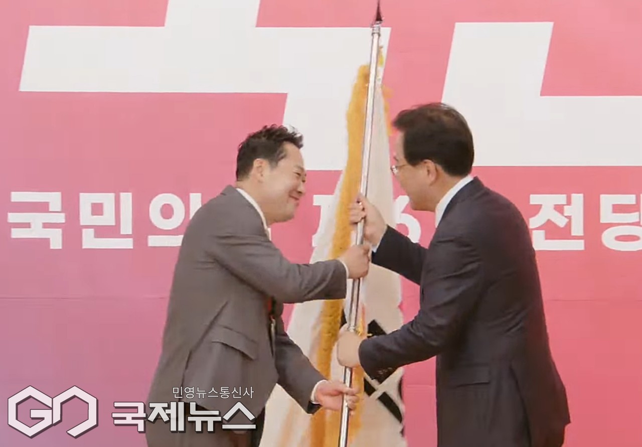 ▲송언석 국민의힘 원내대표는 26일 오후 국회 도서관에서 열린 제6차 전당대회 결선투표에서 당선된 장동혁 대표에게 당기를 전달하고 있다./사진공동취재