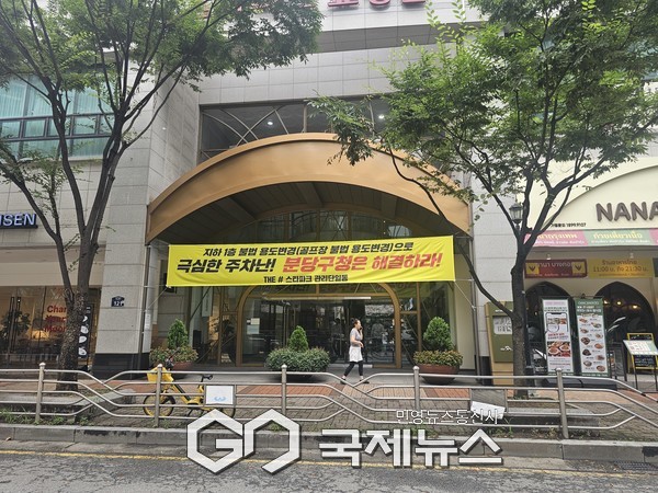 ▲ 정자동 스타파크 상가 출입구에 불법 용도변경으로 주차난을 호소하는 현수막이 걸렸다.  [사진=손병욱기자]