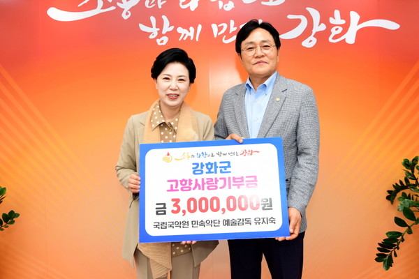 국립국악원 민속악단 유지숙 예술감독(왼쪽)이 고향사랑기부금 300만 원을 전달하며 박용철 군수와 포즈를 취하고 있다. (사진=강화군)