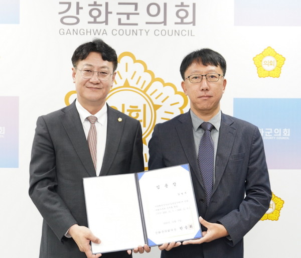 한승희 의장(왼쪽)이 추가 임명된 정책지원관에게 임용장을 수여한 후 기념촬영을 하고 있다. (사진=강화군의회)